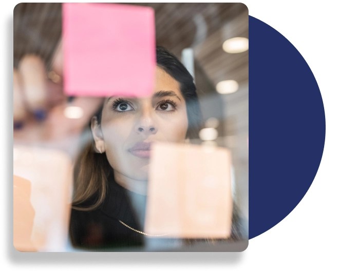 A professional sticks sticky notes on a reflective surface.