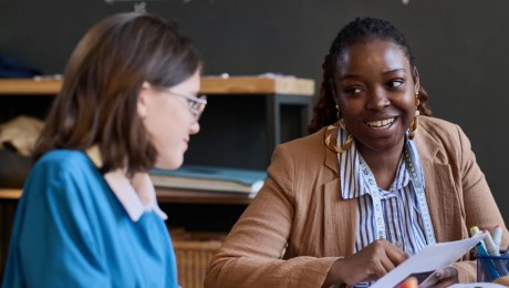 A teacher talking to student during sewing class.