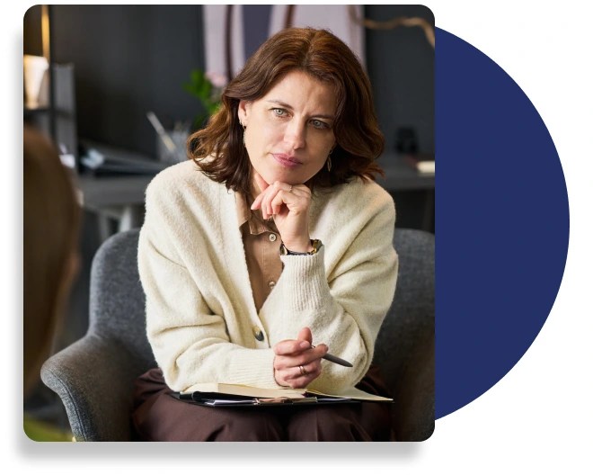 A therapist listening intensely to their patient whilst taking notes.